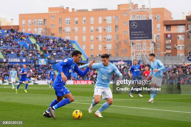 Mason Greenwood of Getafe CF on the ball whilst under pressure from Fran Beltran of Celta Vigo during the LaLiga EA Sports match between Getafe CF...