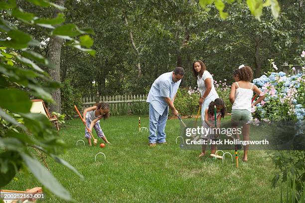 young couple playing croquet with their three daughters - croquet fotografías e imágenes de stock