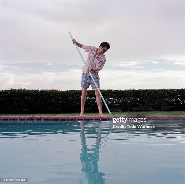 man cleaning swimming pool - tâche fastidieuse photos et images de collection