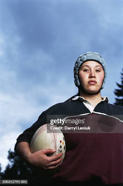 young female rugby player holding ball, close-up, portrait - rugby portraits stock-fotos und bilder