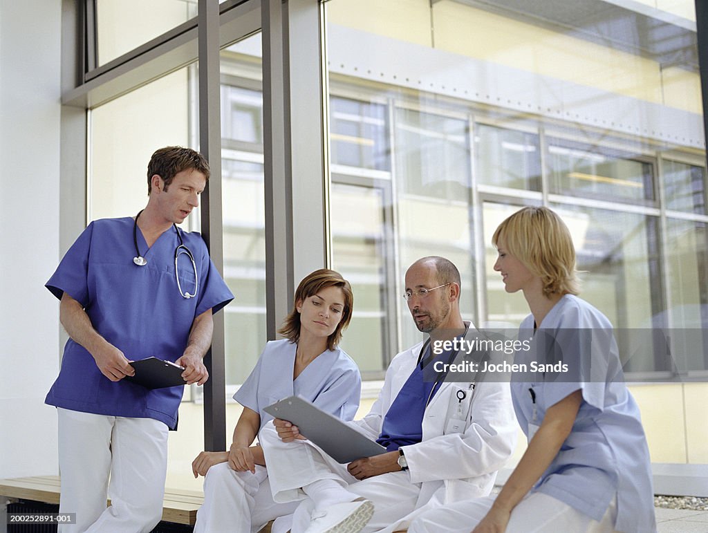 Doctors and nurses talking by window in hospital