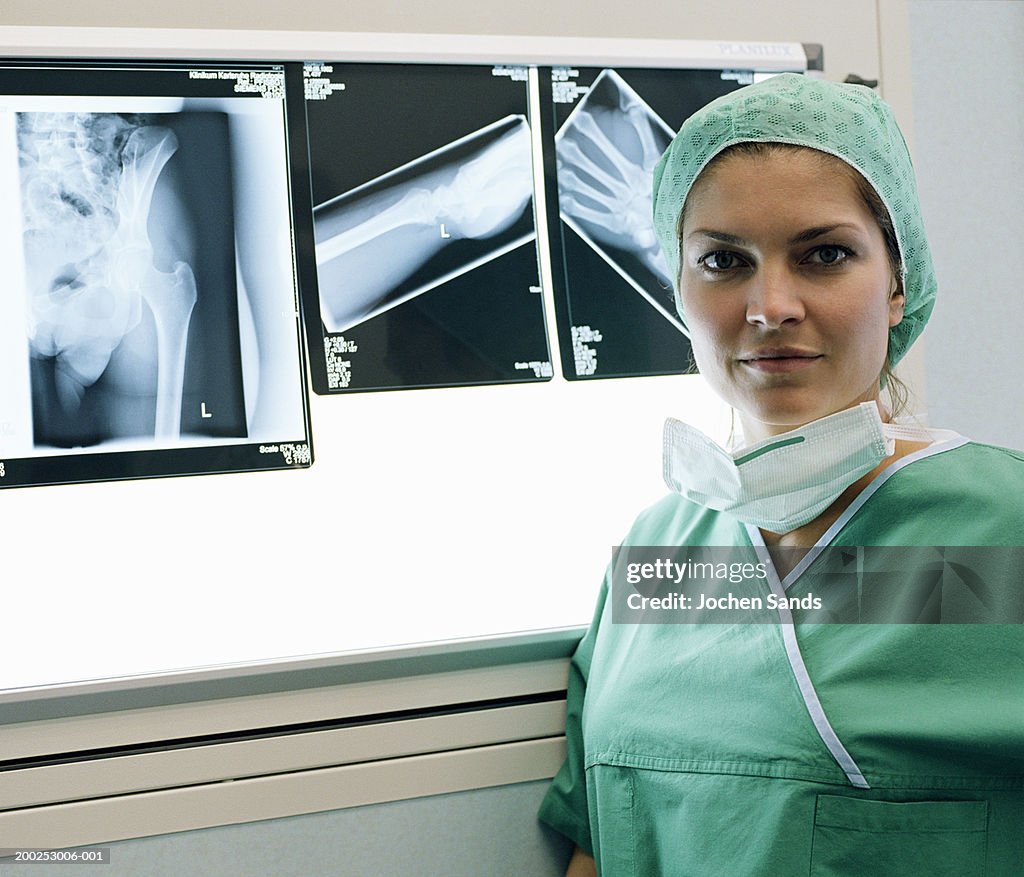 Female doctor standing by x-rays, portrait, close-up