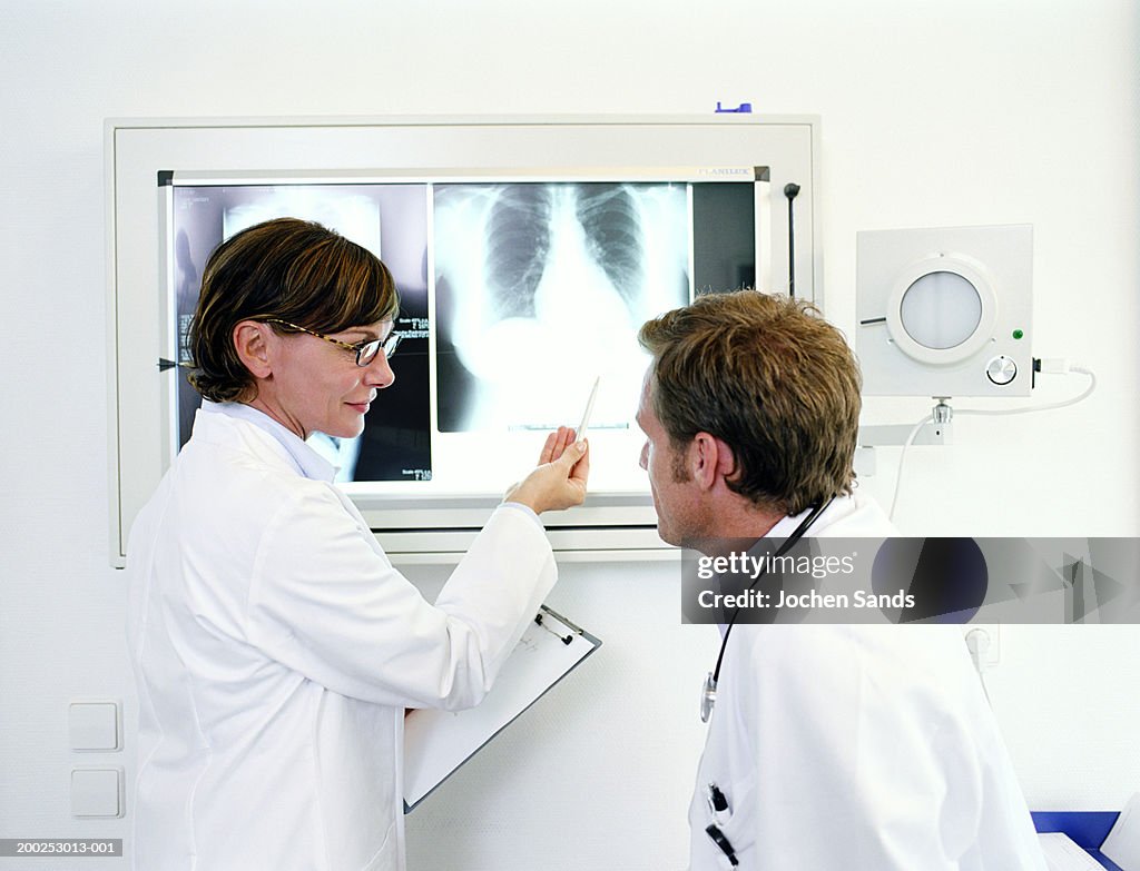 Female doctor pointing at x-ray by male doctor