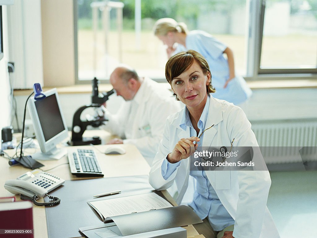 Female doctor sitting in office, portrait