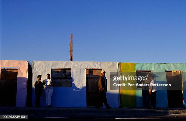 township residents walk on a road as the sun sets in khayeliltsh - refugee camp stock pictures, royalty-free photos & images