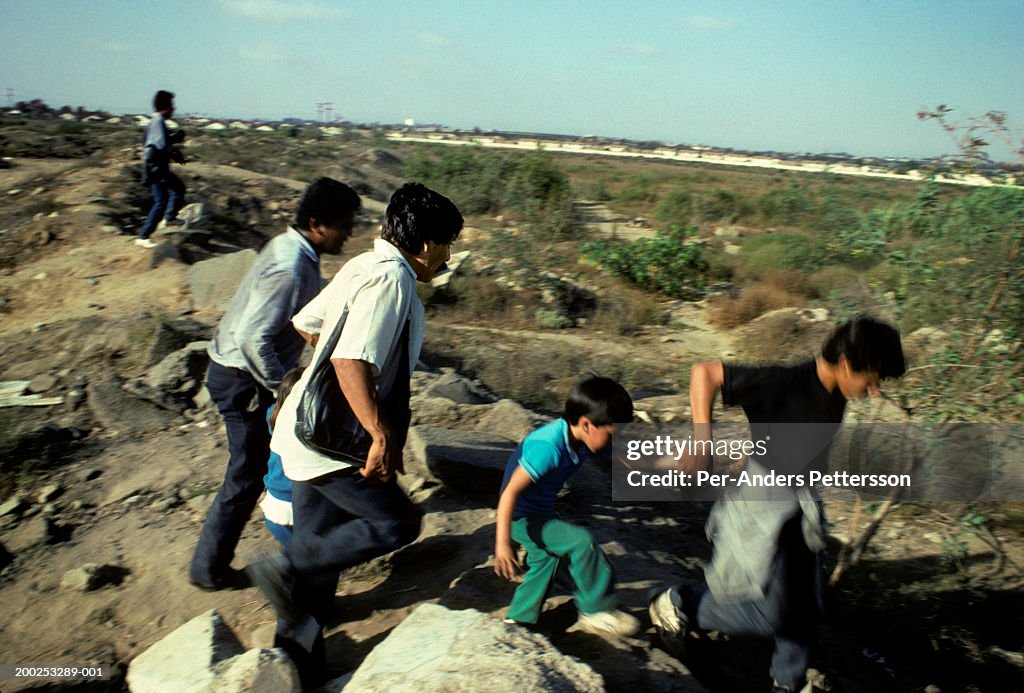 Mexican family runs over the border illegally into the United States in San Diego, California