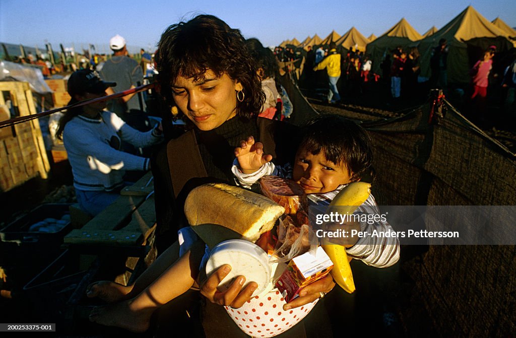 An ethnic Albanian woman and daughter queues for food in a refugee camp in Skopje, Macedonia