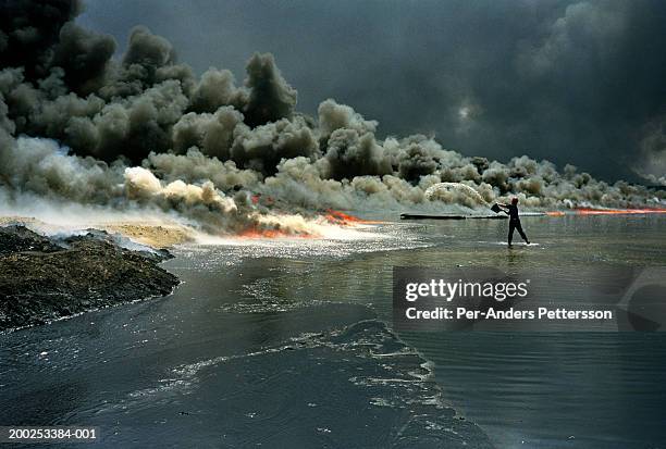 man tries to put out oil well on fire at burhan oilfield in kuwait - persian gulf war fotografías e imágenes de stock