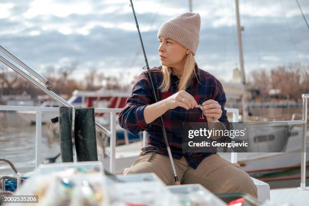 woman attaching lure to fishing line - fishing tackle stock pictures, royalty-free photos & images
