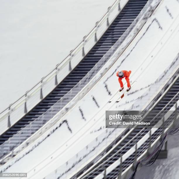 ski jumper skiing down ramp, approaching jump - salto con gli sci foto e immagini stock