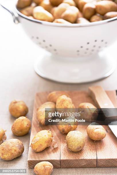 potatoes on wooden chopping board, close-up - 新じゃが ストックフォトと画像