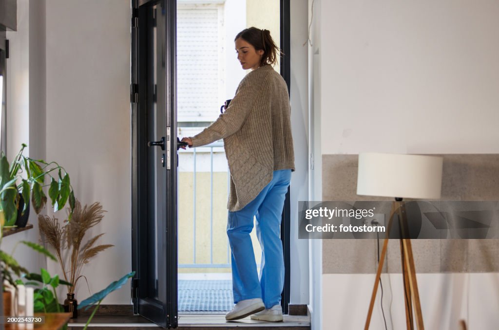 Young nurse exiting her front door when leaving for work in the morning