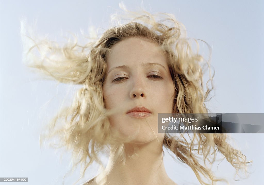 Young woman with hair blowing in wind, portrait, close-up