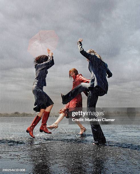 three women having fun in rain - dancing in the rain stock pictures, royalty-free photos & images