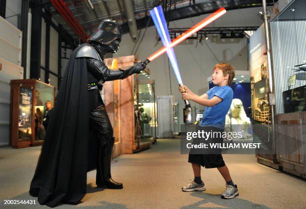 Seven year-old Jet Wigley takes on Darth Vader with a "lightsaber" at the launch of 'Star Wars: Where Science Meets Imagination' exhibition developed...