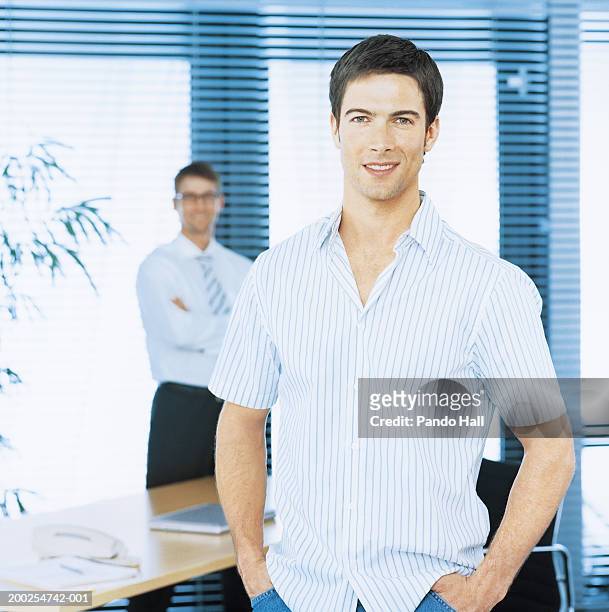 man in office, hands in pockets, smiling, portrait - manga curta - fotografias e filmes do acervo