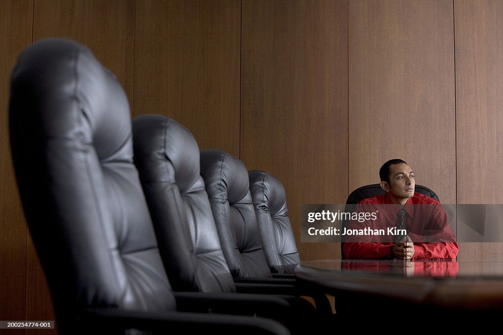 Young businessman sitting in board room