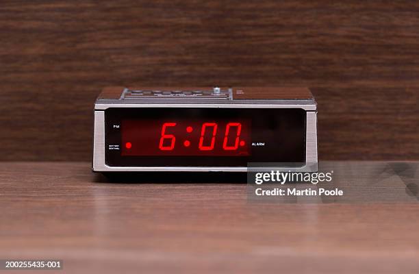 digital alarm clock on wooden surface - red alarm clock stock pictures, royalty-free photos & images