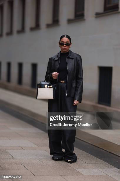 Cherifa Akili seen wearing YSL black sunglasses, gold earrings, Falke black wool knit turtleneck sweater, 12 Storezz black leather jacket, Zara black...