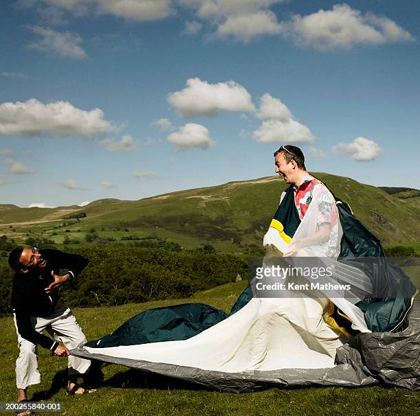 two men assembling tent outdoors, laughing - 2005 fotografías e imágenes de stock