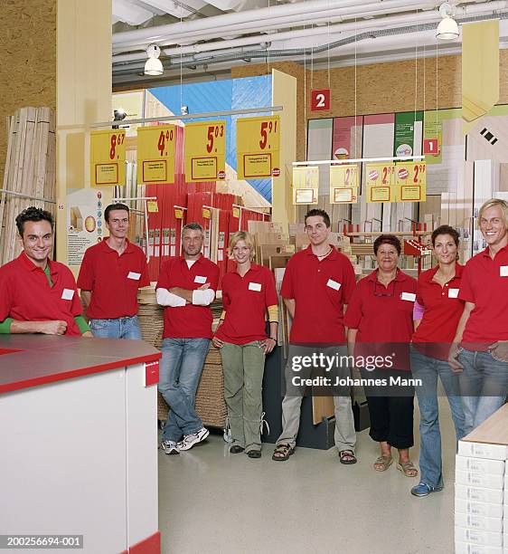 group of workers in hardware shop, smiling, portrait - t shirt uniform stock pictures, royalty-free photos & images