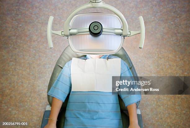 boy (10-12) lying on dentist's chair, overhead view - dentists chair stock-fotos und bilder