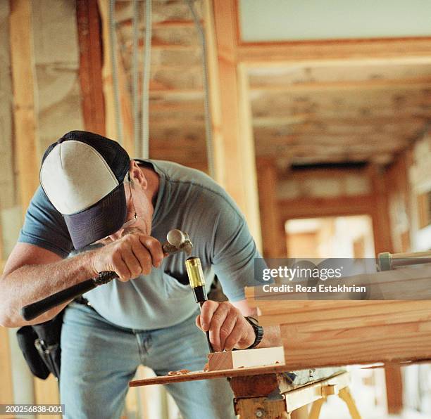 carpenter chiseling out wood at home renovation site - chisel fotografías e imágenes de stock