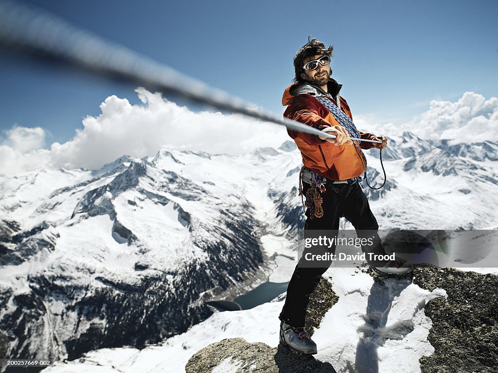 Male mountain climber pulling rope taut, portrait