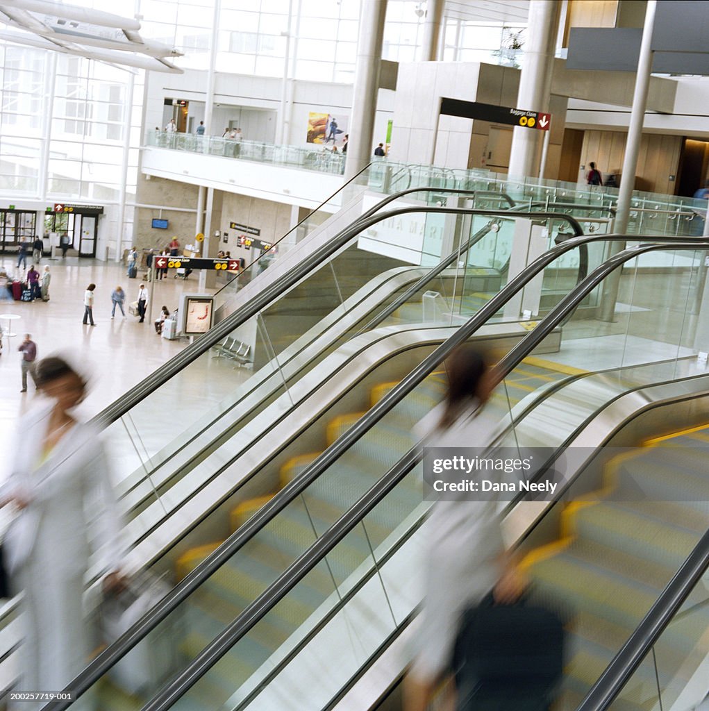 People using escalator in airport (blurred motion)