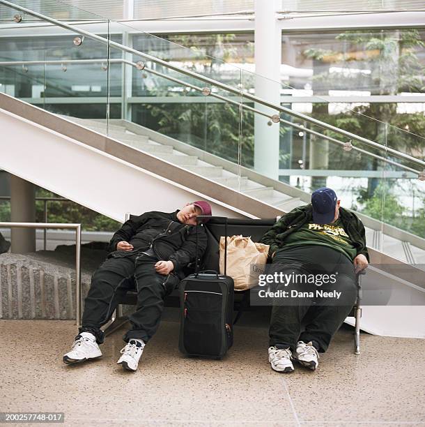 two men sleeping on bench next to escalator - man sleeping with cap stock pictures, royalty-free photos & images