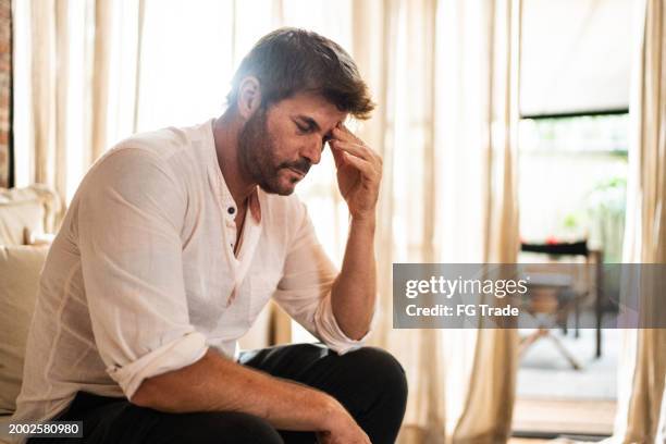 trauriger reifer mann zu hause - burnout stock-fotos und bilder