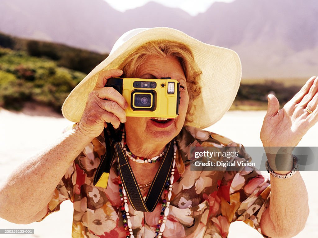 Senior woman taking photograph outdoors