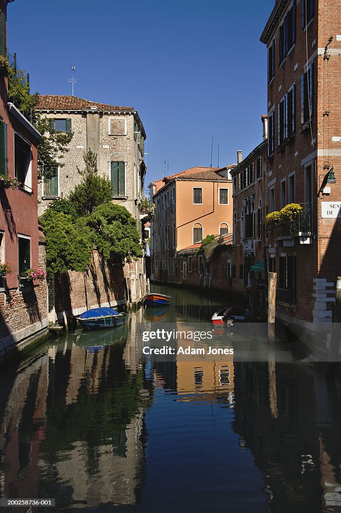 Italy, Venice, boats and buildings reflecting in waters of inner canal