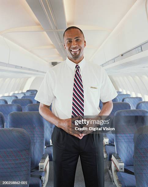 ar de steward pé no corredor de avião, sorridente, retrato - tripulação imagens e fotografias de stock