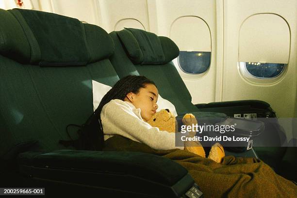 girl sleeping with stuffed animal in commercial airplane - david de lossy sleep stock pictures, royalty-free photos & images