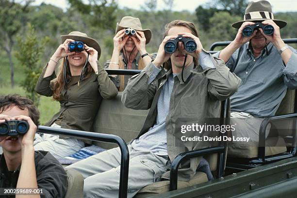 group of friends on off road vehicle with binoculars - safari fotografías e imágenes de stock