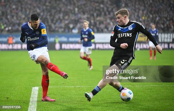 Steven Skrzybski of Holstein Kiel crosses the ball past Derry John Murkin of FC Schalke 04 during the Second Bundesliga match between Holstein Kiel...