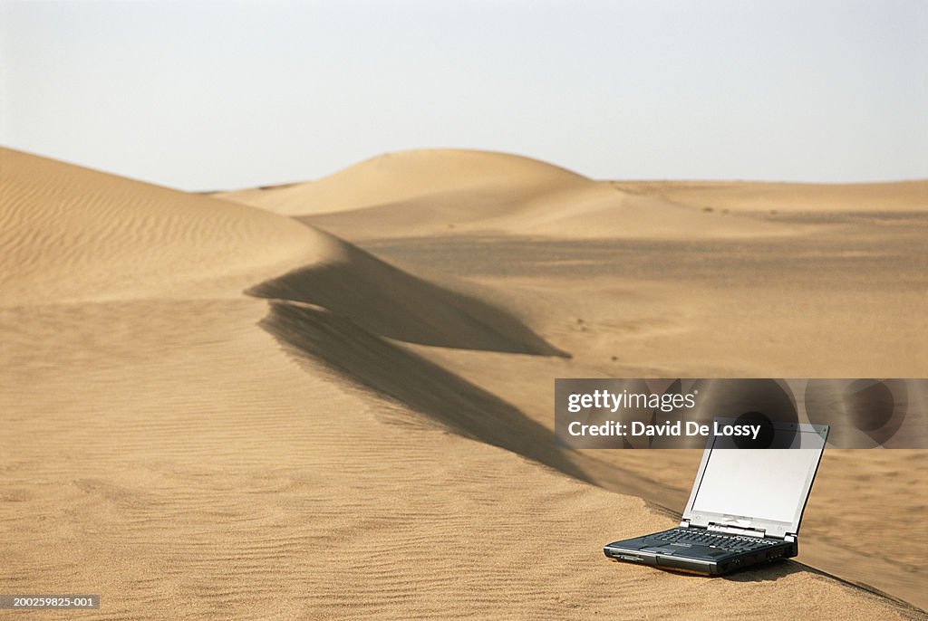 Laptop on sand in desert