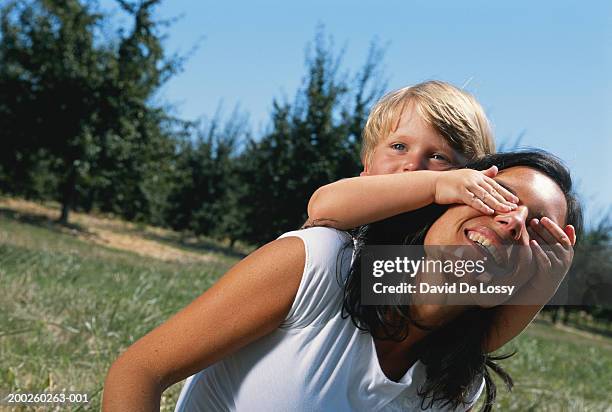 boy covering mother's eyes - hands covering eyes stock pictures, royalty-free photos & images