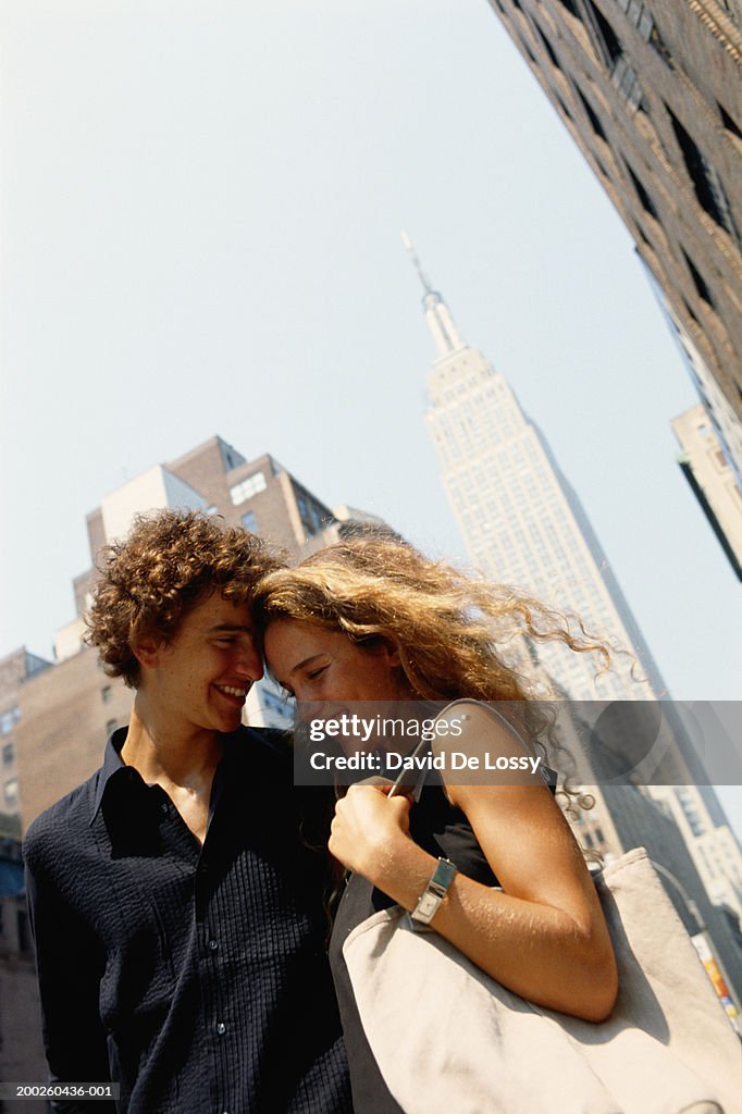 Young man and woman standing, low angle view