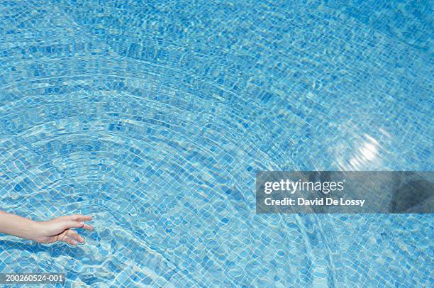 woman testing water in swimming pool - testing the water 英語の慣用句 ストックフォトと画像