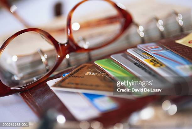 stock of credit cards with spectacles on desk - credit card and stapel stockfoto's en -beelden