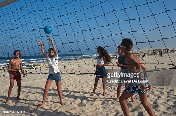 teenage girls and boys (16-17) playing beach volley ball - girls beach volleyball stock pictures, royalty-free photos & images