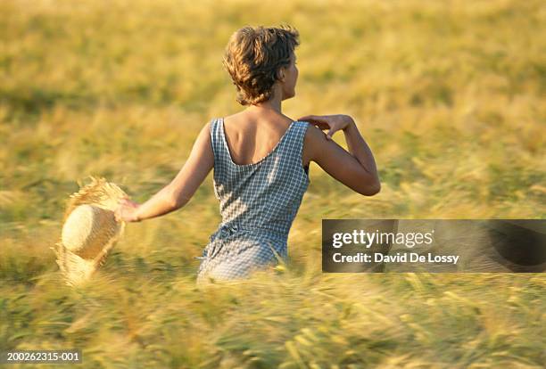 woman running in field, rear view - woman short blonde hair stock pictures, royalty-free photos & images