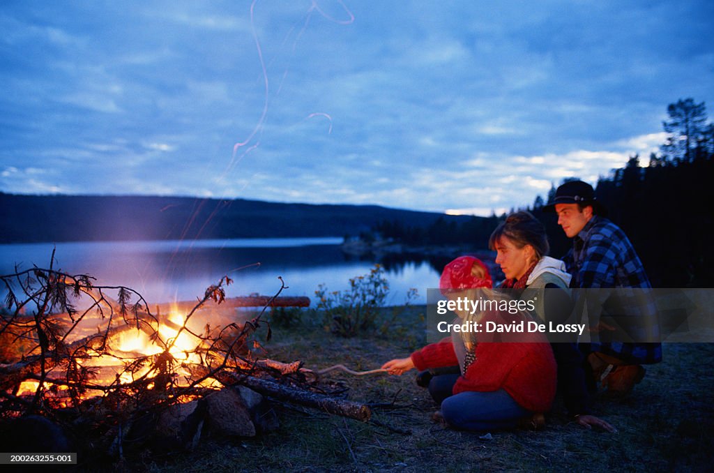 Parents with daughter camping on river bank