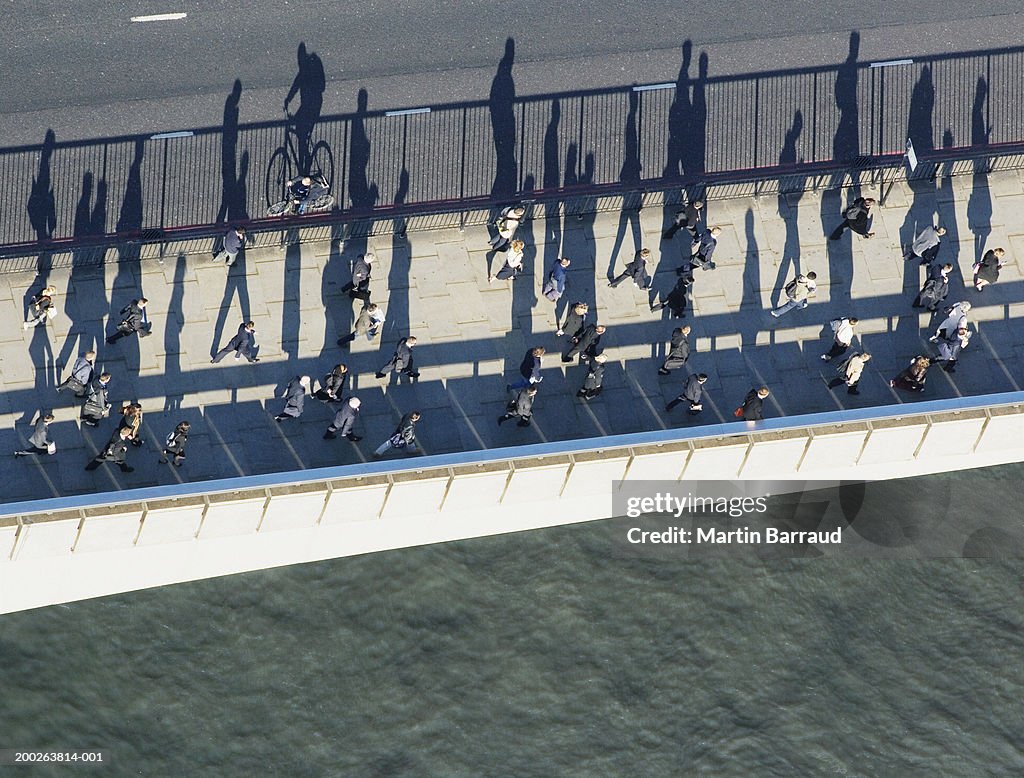 People walking on foot path on bridge, aerial view