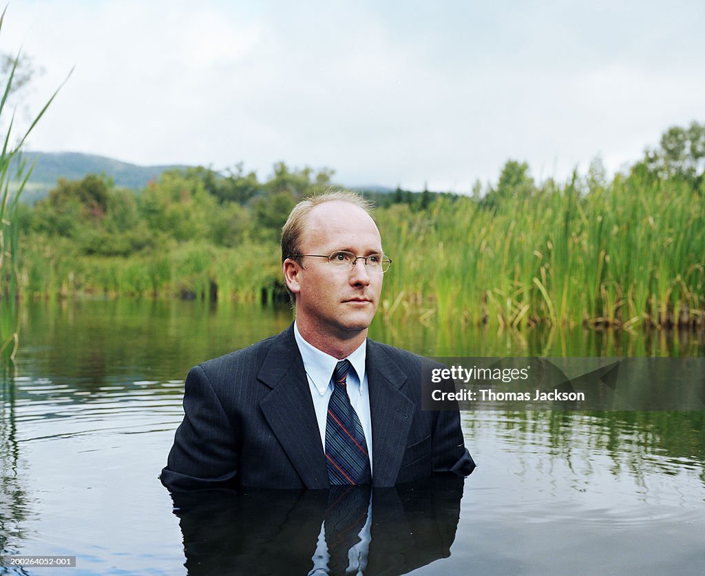 Businessman standing chest deep in water