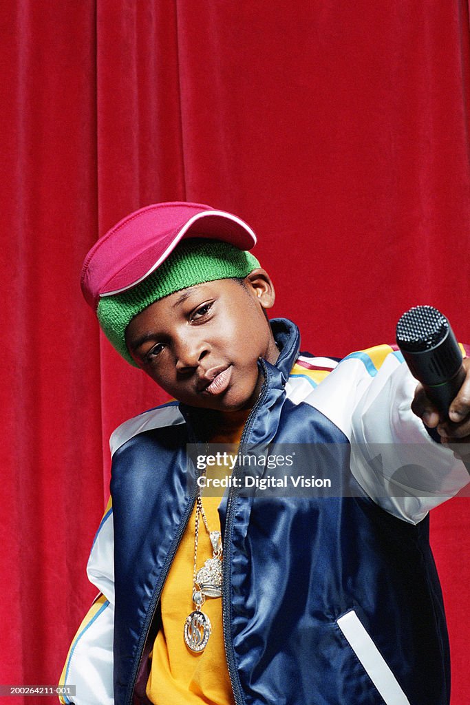 Boy (9-11) holding out microphone, close-up