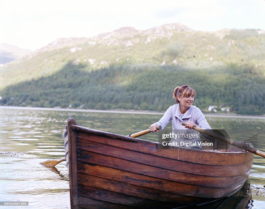 Woman rowing boat, smiling