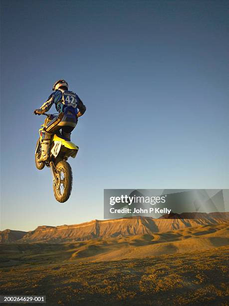 motocross racer in mid air, rear view - motorized vehicle riding stock-fotos und bilder